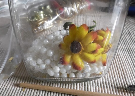 string of pearls in the bottom of a glass jar