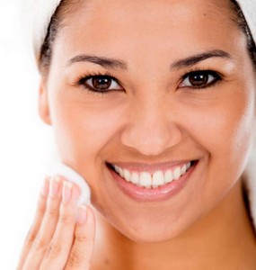 woman cleaning her face with cotton circle