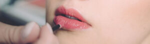 applying pink lip balm