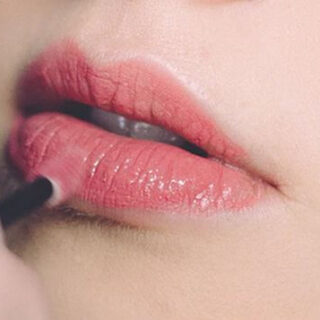 applying pink lip balm