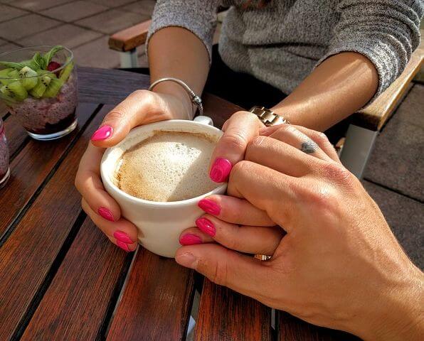 woman's hands holding coffee