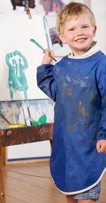little boy painting on an easel