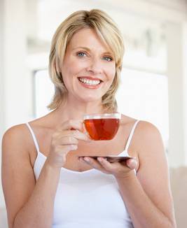 woman drinking clear herb tea