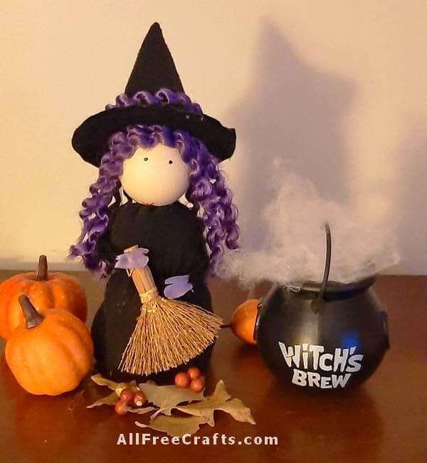 front view of sock witch display with pumpkins, broom and cauldron