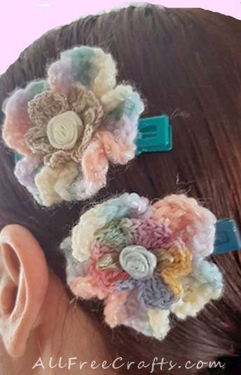 two crocheted five petal hair clips being worn in hair